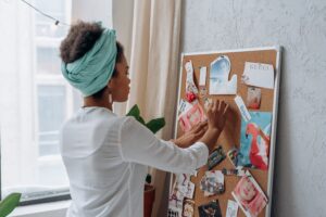 A woman standing making vision board in her home